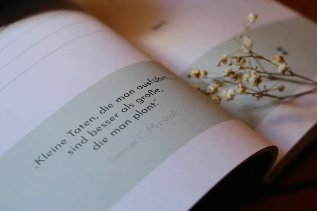 Aufgeschlagenes Journal mit Zitat und Trockenblumen